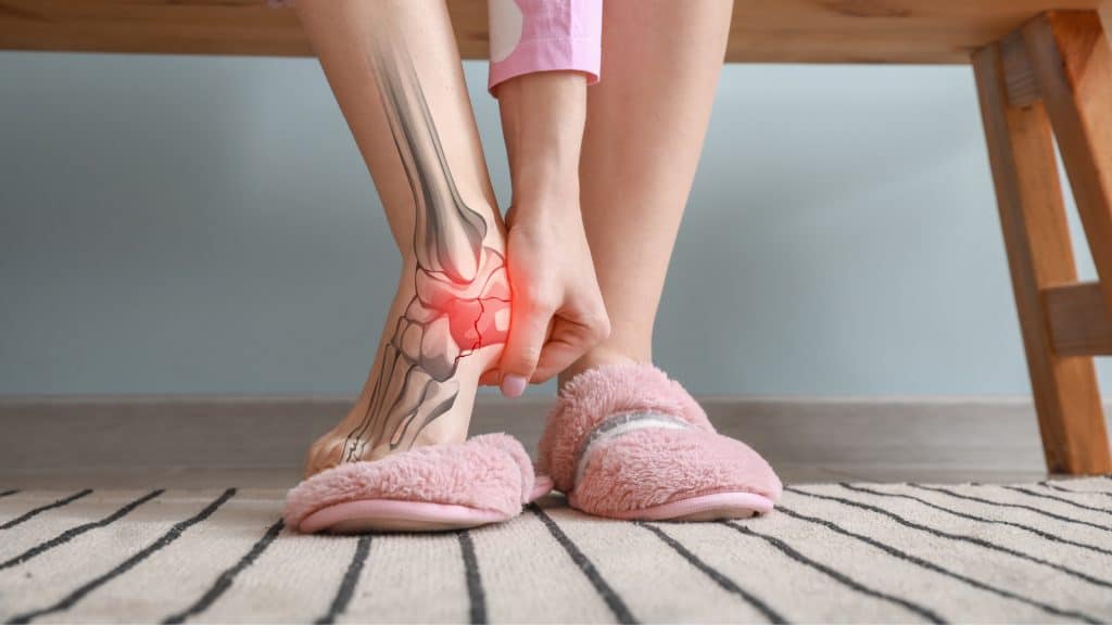 girl holding her heel that is in pain